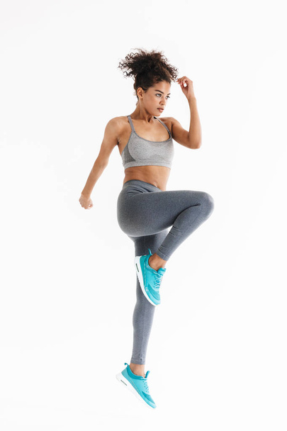 Amazing stronger sports fitness african woman make exercises isolated over white wall background. - Φωτογραφία, εικόνα