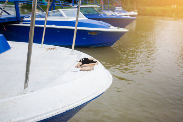 Hasarlı sürat teknesi nehre park ediyor. Beyaz ve mavi sürat teknesi hasar gördü. Tayland. - Fotoğraf, Görsel