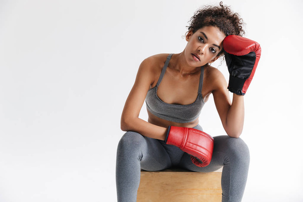 Beautful young amazing sports fitness african woman boxer posing isolated over white background in gloves. - Foto, Bild