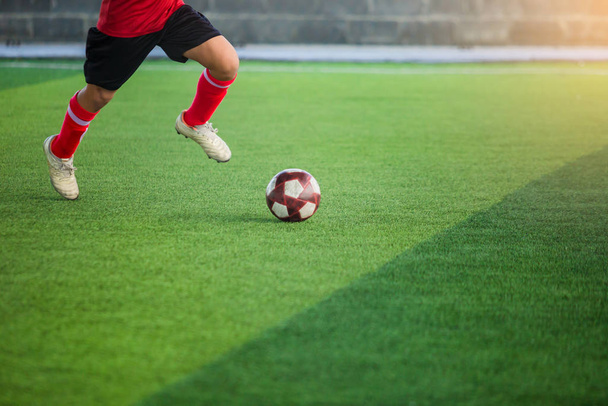 çocuk futbolcu hız bulanık futbolcu arka plan ile yapay çim üzerinde hedefe topu ateş etmek için çalıştırın. Futbol akademisinde futbolcu eğitimi. - Fotoğraf, Görsel