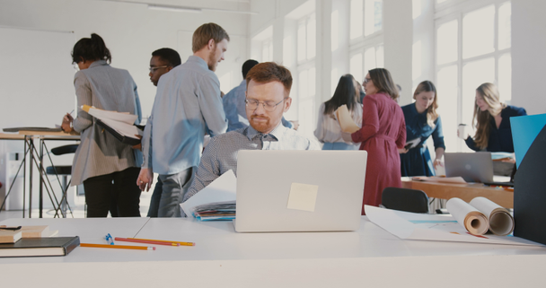 Stresli genç ofis çalışanı adam havada kağıtları atma, meşgul modern ofis masa Kırmızı Destan yürüme. - Video, Çekim