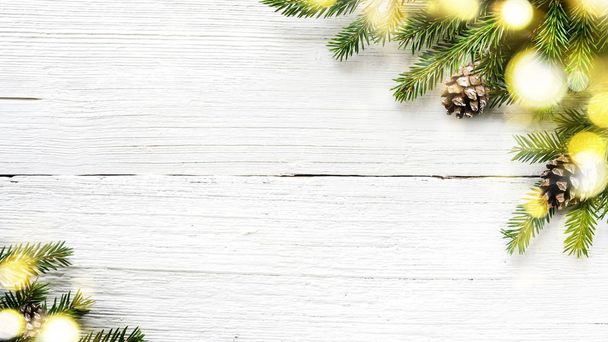 Christmas tree branches and pine cones on white wooden background. - 写真・画像