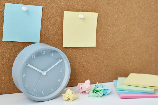 Concept of notes, goals, memo or action plan. Sticky notes on a cork board and alarm clock  in workplace office or home - Photo, Image