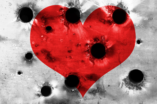 σχήμα κόκκινο καρδιά σε μεταλλική πλάκα με τρύπες από σφαίρες - Φωτογραφία, εικόνα