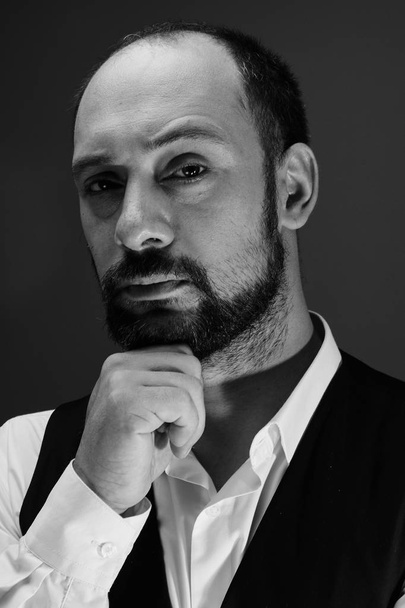 Black and white portrait of a serious pensive handsome bearded adult man in the studio - Foto, immagini