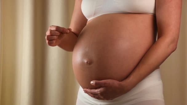 Femme enceinte touchant son ventre avec les mains - Séquence, vidéo
