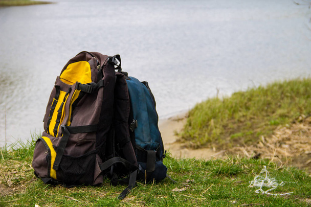 Two touristic backpacks on the riverbank. Hike concept - Фото, зображення