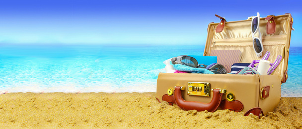 Full open suitcase on tropical beach background, banner - Foto, Bild