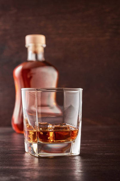 Glass of whiskey on a wooden table - Valokuva, kuva