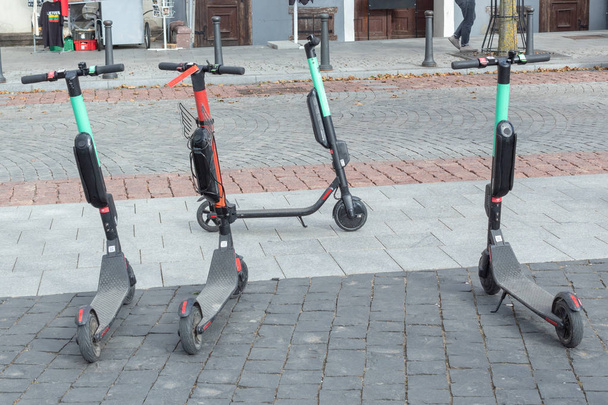 Четыре электроскутера припаркованы у дороги в центре города
. - Фото, изображение