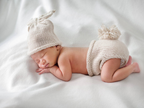 Newborn baby sleeping and wearing rabbit crocheted clothes, whit - Valokuva, kuva