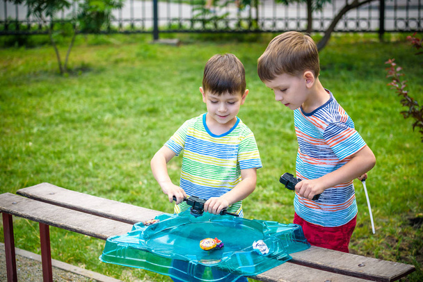 Two boys playing with a spinning top kid toy. Popular children g - Photo, Image