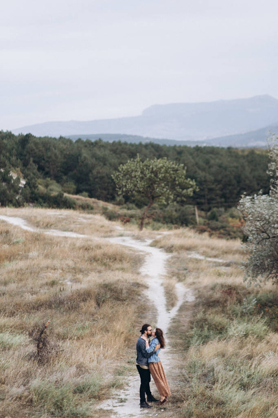 Fidanzato e fidanzata corrono in alta erba gialla nella foresta
. - Foto, immagini