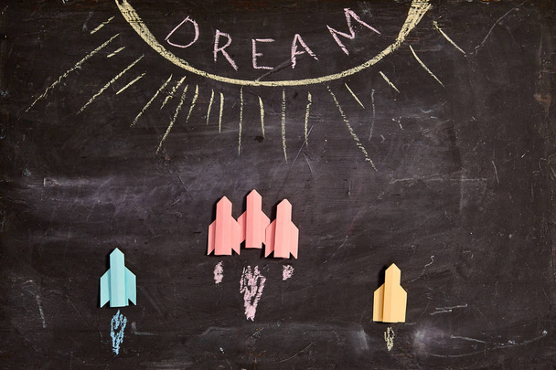 Concept for achieving goal and dream, business motivation: Paper rockets on blackboard - Photo, Image