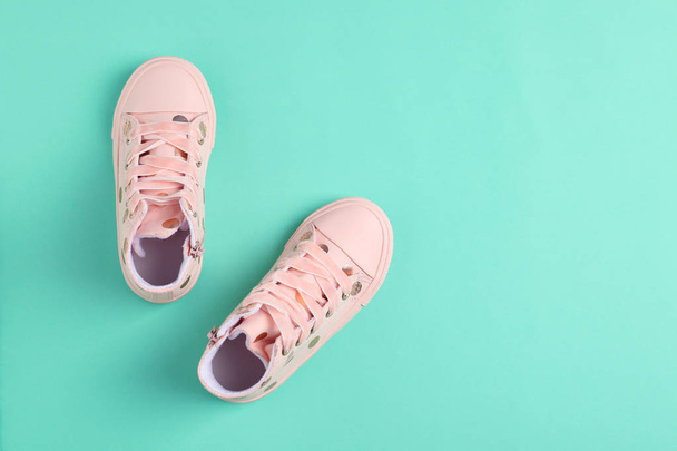 Pair of stylish child shoes on turquoise background, flat lay. Space for text - Fotoğraf, Görsel