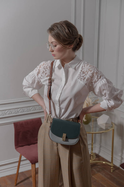 Fashionable portrait of a girl with a bag on a wide belt. - Fotoğraf, Görsel