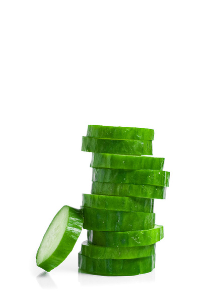 Komkommer en plakjes geïsoleerd op witte achtergrond - Foto, afbeelding