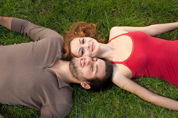 Young couple resting on the grass - Foto, afbeelding