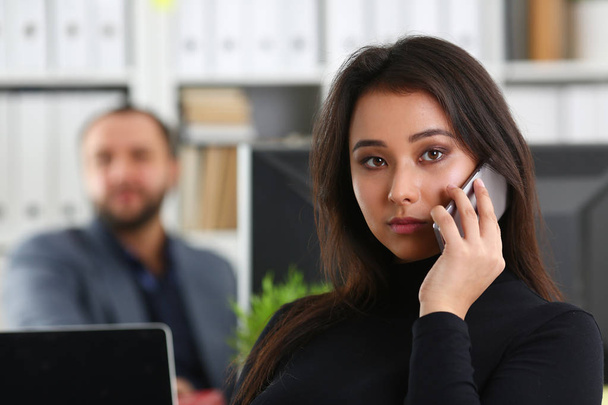 giovane bella donna bruna in ufficio lavora con il suo capo tenere smartphone in mano
 - Foto, immagini
