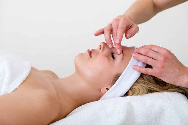 Masseuse massaging a woman eyebrow area. - Photo, Image
