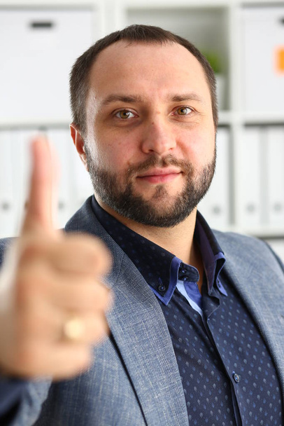 mladý pohledný nadějný podnikatel práce v kanceláři objeví velké prsty - Fotografie, Obrázek