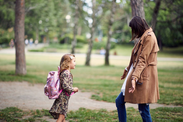 schoolgirl runnig to her mother after first day of school - Fotografie, Obrázek