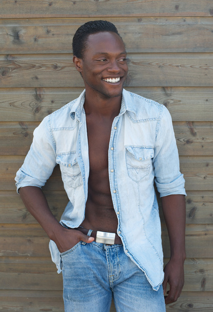 Jovem negro sorrindo contra fundo marrom
 - Foto, Imagem
