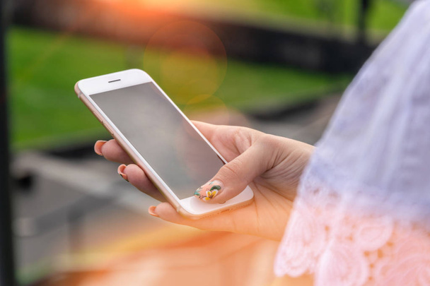 Vrouw texting op slimme telefoon op tijdens zonsondergang - Foto, afbeelding