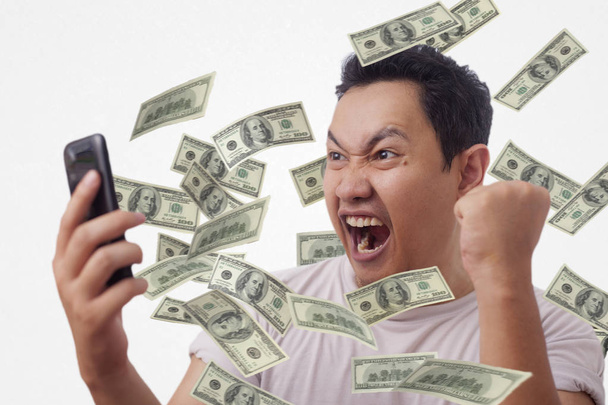 Úspěšný mladý muž získávání peněz z jeho inteligentního telefonu - Fotografie, Obrázek