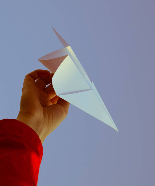 White paper airplane in hand against the sky. A symbol of freedom on the Internet - Fotografie, Obrázek