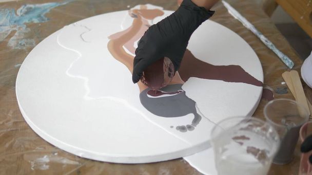 Workshop of liquid acrylics. Fluid art. female hands pouring acrylic paint on canvas. Creative work - Fotoğraf, Görsel