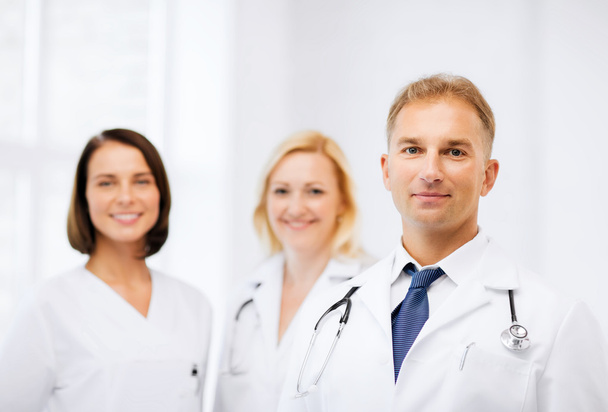 Doctor with stethoscope and colleagues - Photo, Image