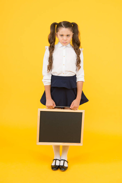 Sad news. Schoolgirl offended pupil informing you. School girl hold blank chalkboard copy space. Announcement and promotion. Girl school uniform hold blackboard. Back to school. Something happened - Fotoğraf, Görsel