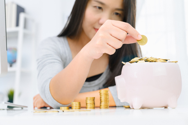 Žena, která dává zlatou minci do růžového prasátko. Úspora peněz, Rozpočtovaná - Fotografie, Obrázek