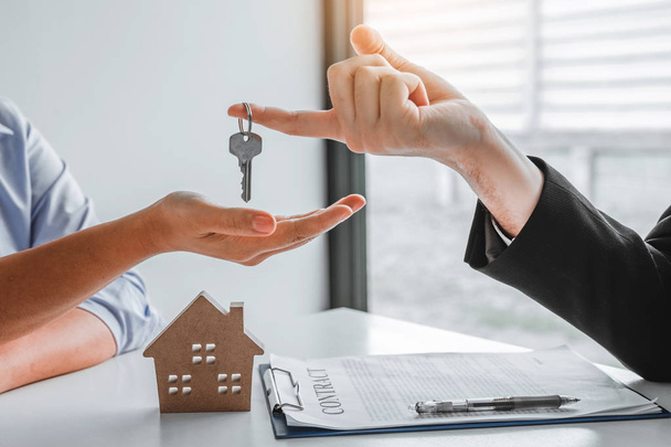 Πώληση πράκτορας δίνοντας κλειδιά του σπιτιού σε γυναίκα πελάτη και υπογραφή - Φωτογραφία, εικόνα