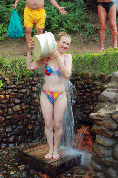Una mujer vierte manantial de agua
 - Foto, imagen