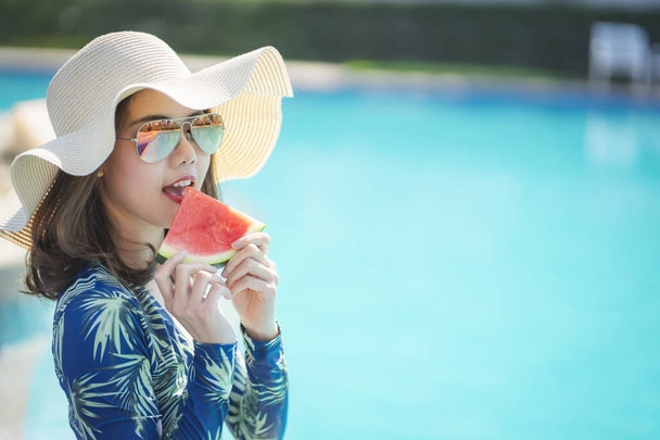 Όμορφη γυναίκα απολαμβάνουν διακοπές στην πισίνα κατά τη θερινή ώρα. - Φωτογραφία, εικόνα
