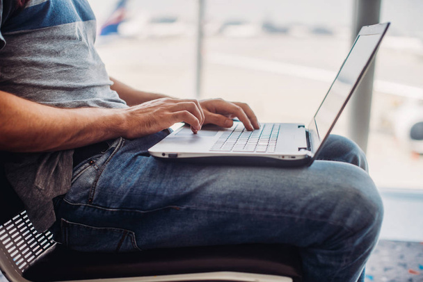Jonge man met laptop in luchthaventerminal - Foto, afbeelding