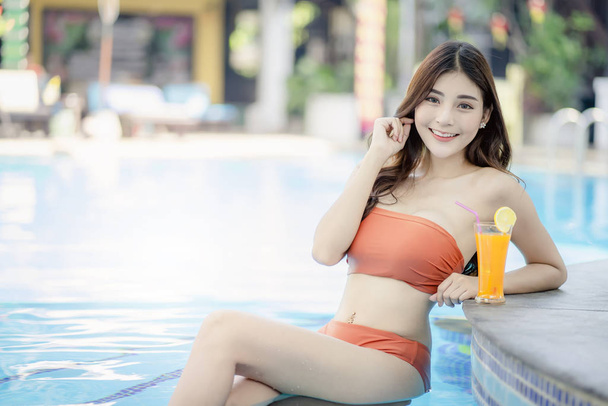 Pretty Woman enjoy vacation at swimming pool during summer time. - Foto, imagen