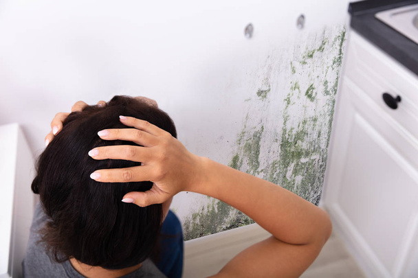 Side View Of A Young Woman Looking At Mold On Wall - Photo, Image
