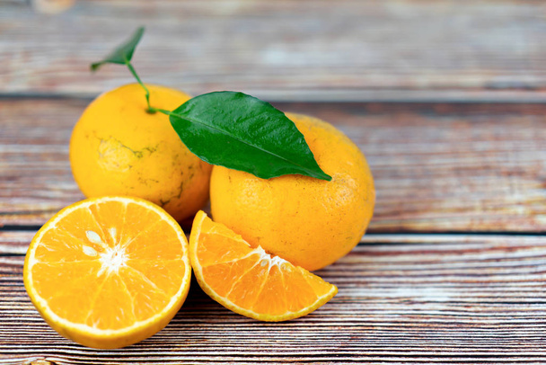 Фрукты апельсина с листом на деревянном столе
 - Фото, изображение