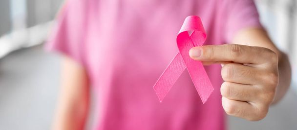 10月乳がん啓発月間、ピンクのTシャツwiの女性 - 写真・画像