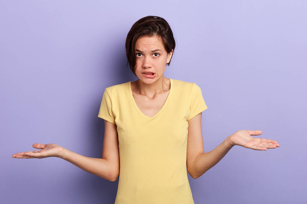 frustrated young serious girl shrugging shoulders isolated over blue background - Foto, afbeelding