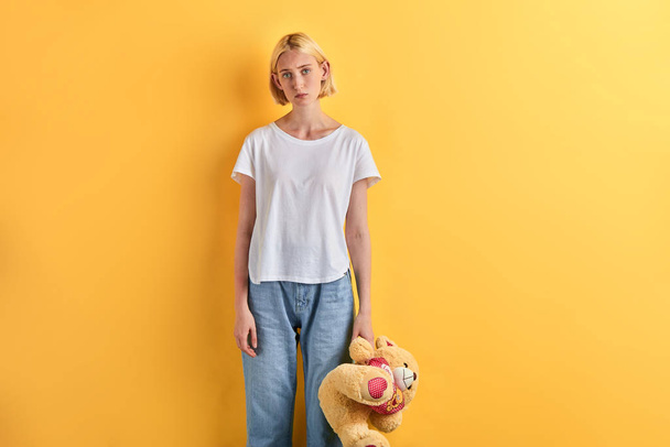 Young beautiful unhappy sad blonde woman holding teddy bear - Foto, immagini