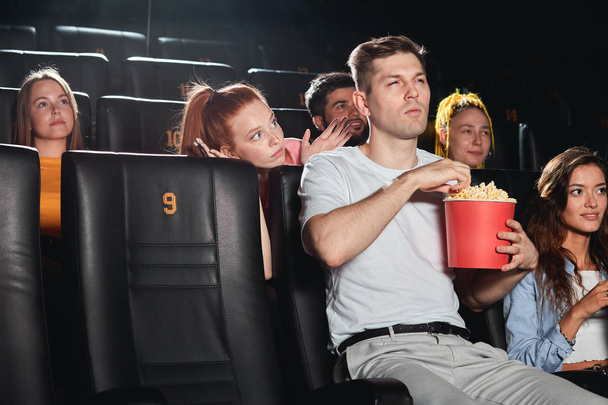 Ο τύπος στο σινεμά ενοχλεί τζίντζερ κορίτσι για να παρακολουθήσουν μια ταινία - Φωτογραφία, εικόνα
