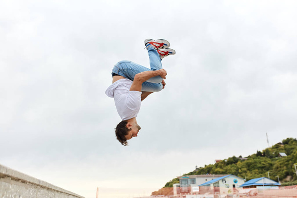 young man throwing a somersault outdoors - Photo, Image