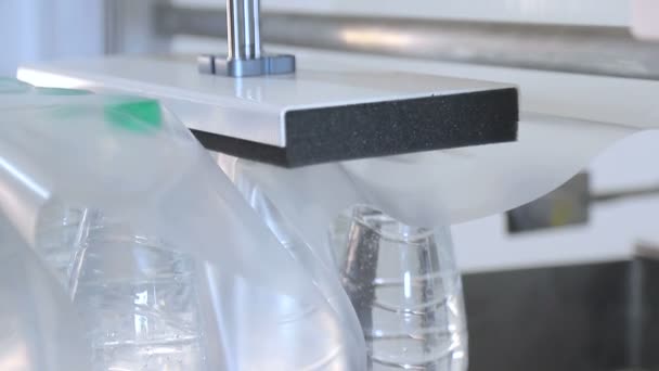 Automatische verpakking van plastic flessen met film in de temperatuur pers. Verpakking van flessen voor verder transport. - Video