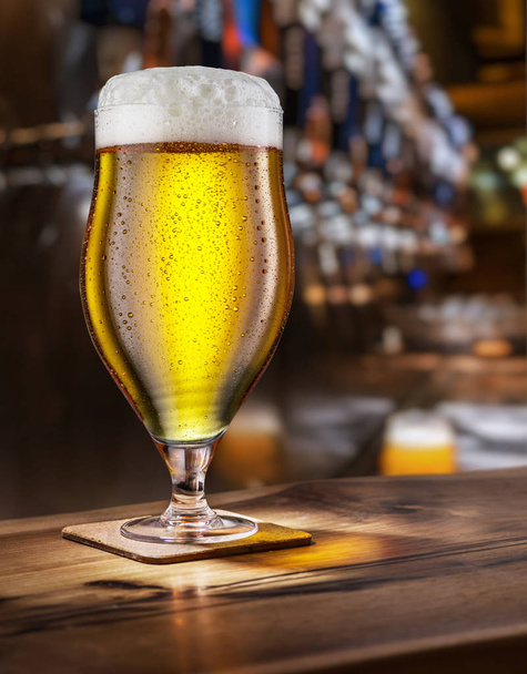 Frosty glass of light beer on the bar counter. - Fotografie, Obrázek