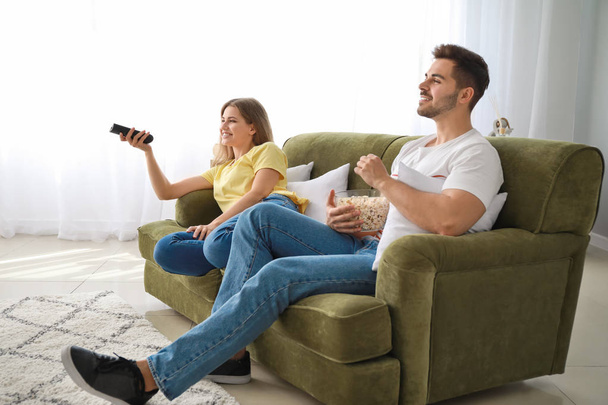 Happy couple watching TV at home - Fotó, kép