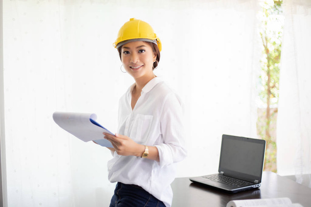 Asian woman engineer working and holding blueprints in office. - Photo, Image